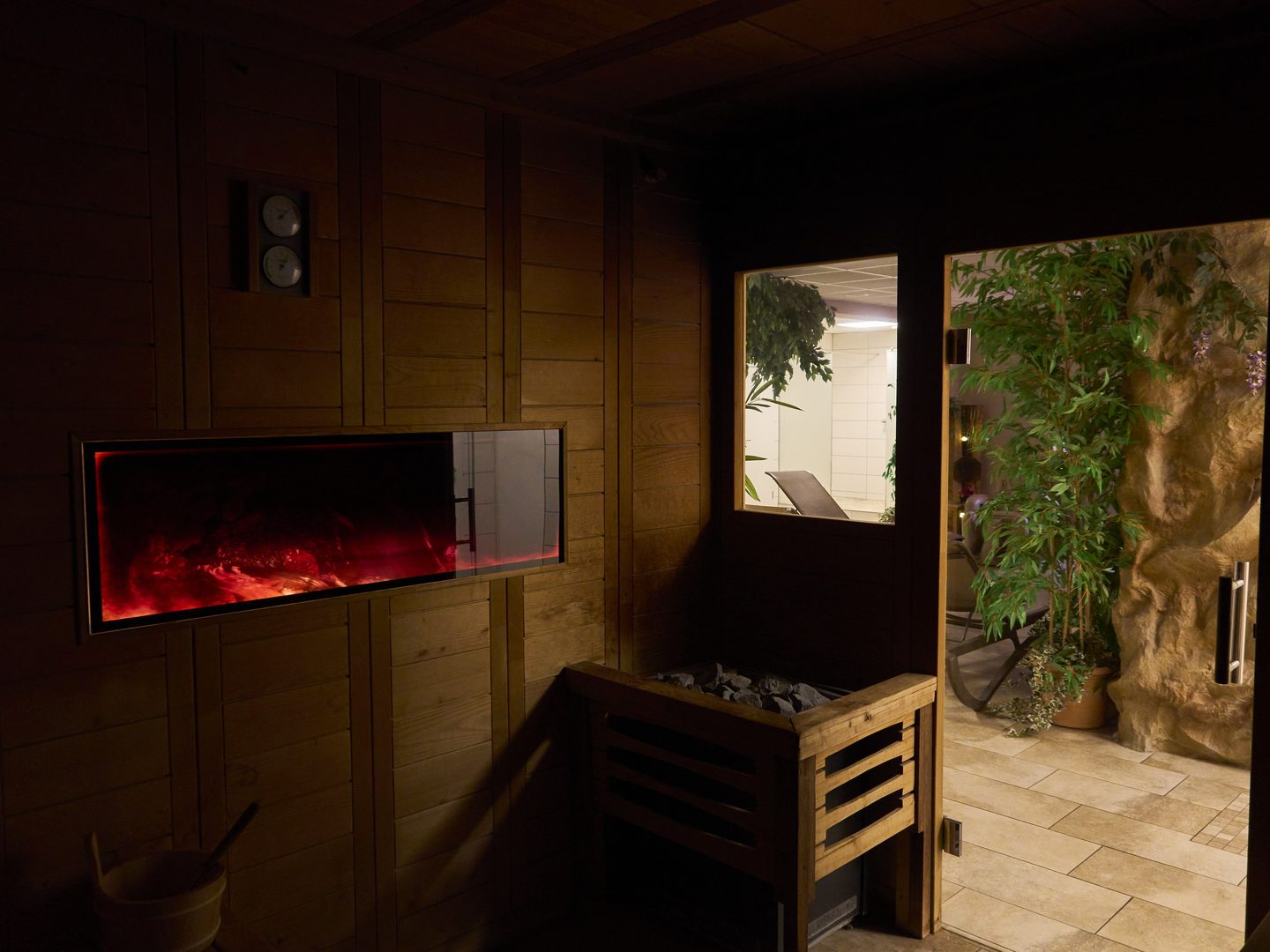 Finnische Sauna mit Saunaofen und beleuchtetem Feuerpaneel